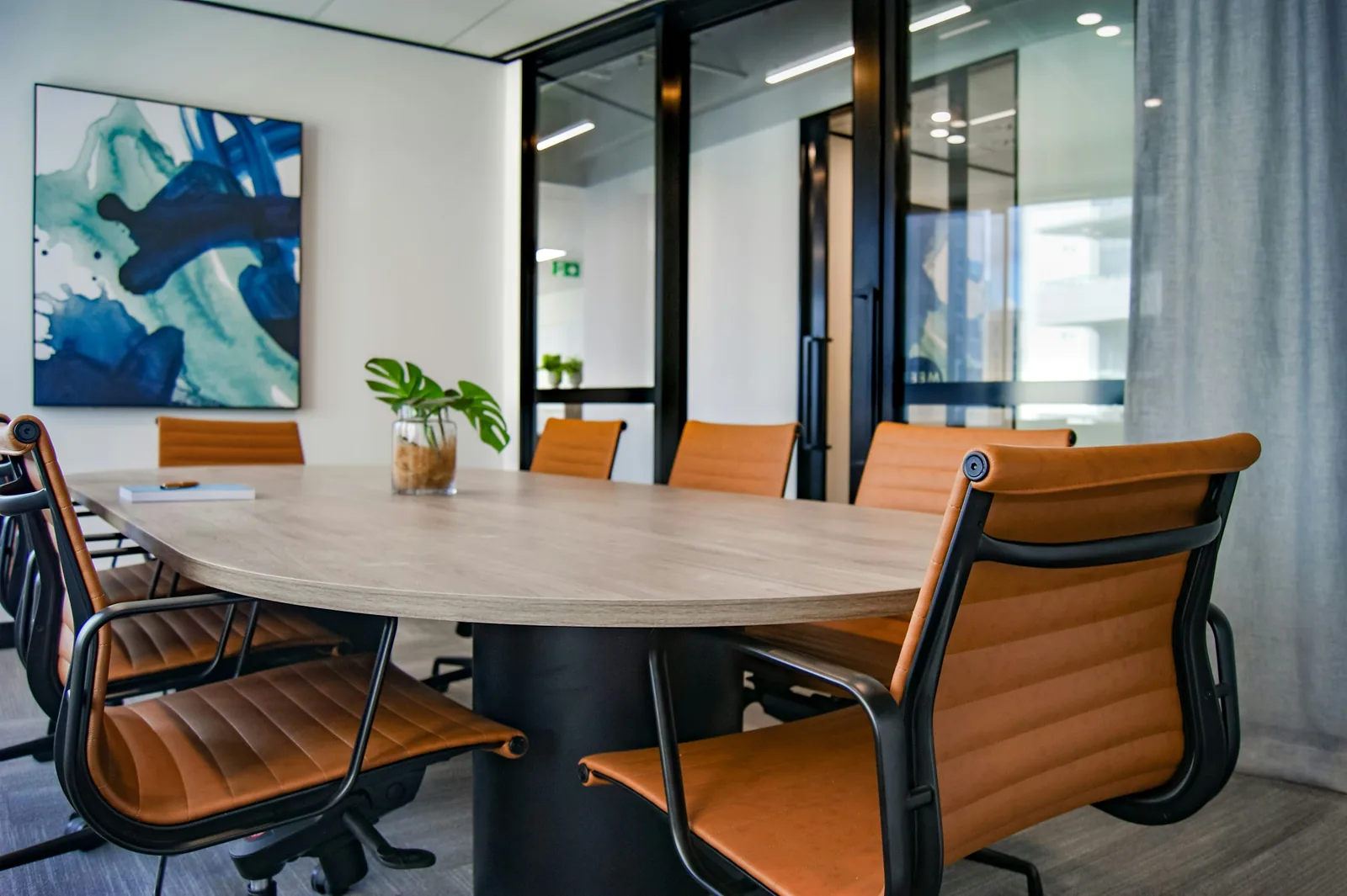 Sala de reuniones con mesa de trabajo, cuadernos y entorno preparado para capacitación regulatoria sin personas visibles
